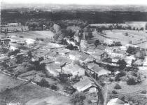                 
    Vue aérienne du village de Champniers. On voit bien au fond le château et l'église. La tour nord possède encore un toit en ardoise, cependant, la tour sud a déjà été rasée et une bâtisse bourgeoise se dresse à son ancien emplacement.                