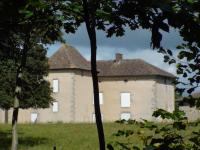 Vue actuelle du chateau de reilhac, les volets blancs sont clos. Devant la batisse, un grand terrain plien de gazon. Le toit est fait de de petites tuiles, tradition de la région.